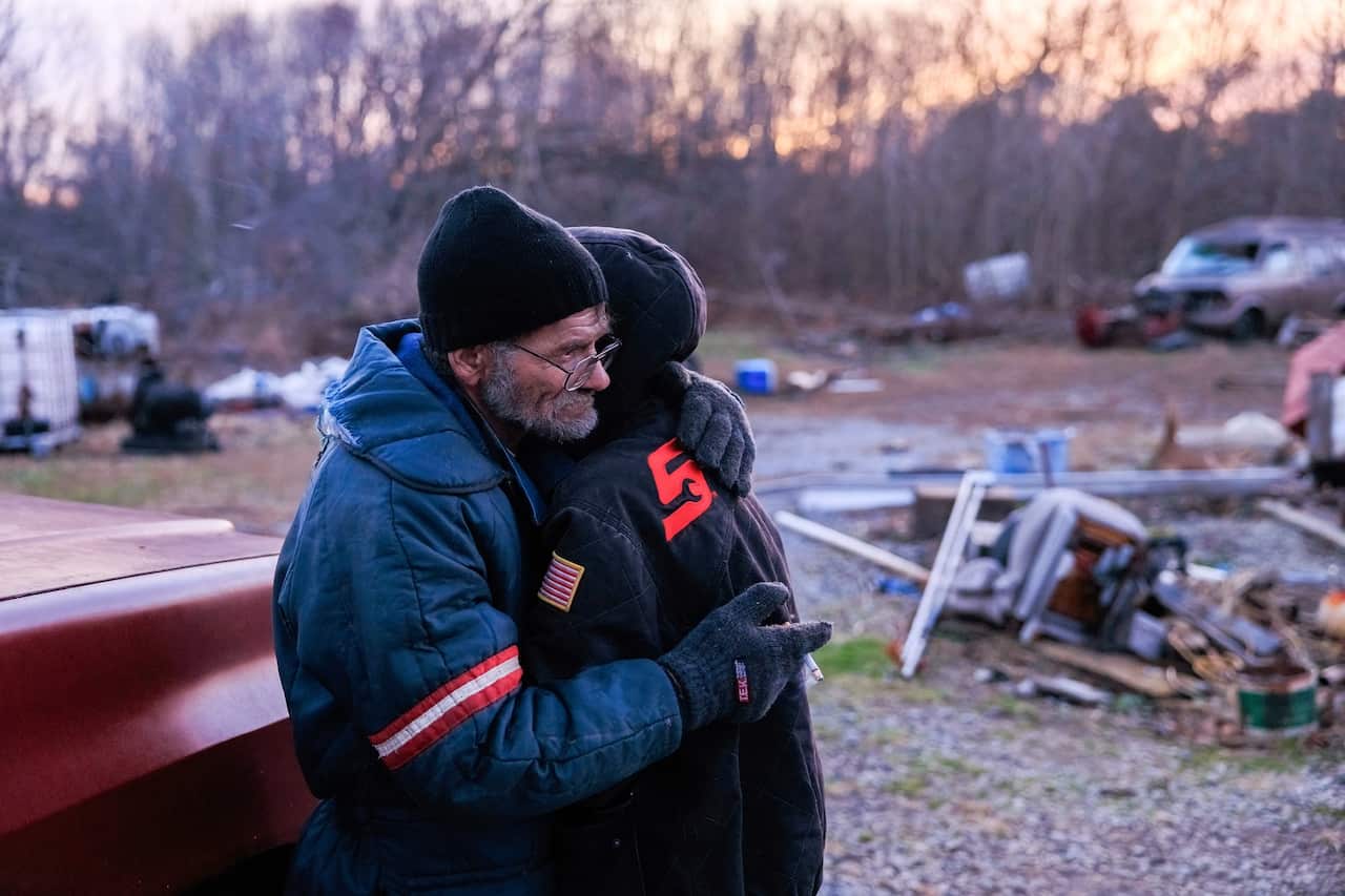 Danny Mensor hugs his girlfriend Shawnee Thompson outside his destroyed home after a tornado tore through rural Kentucky. 
