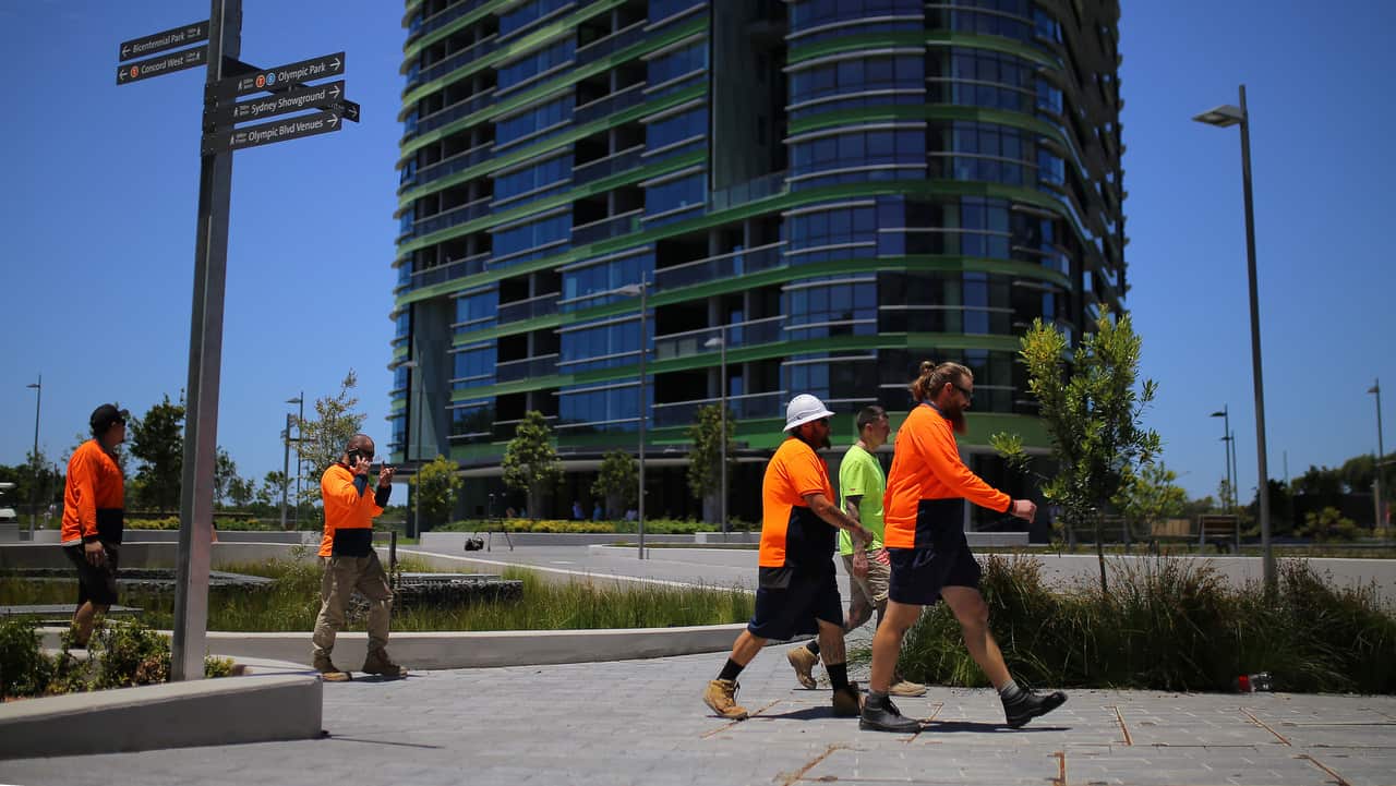 Construction workers in front of Opal Tower.Construction workers in front of Opal Tower. Work is ongoing in some of the apartments.