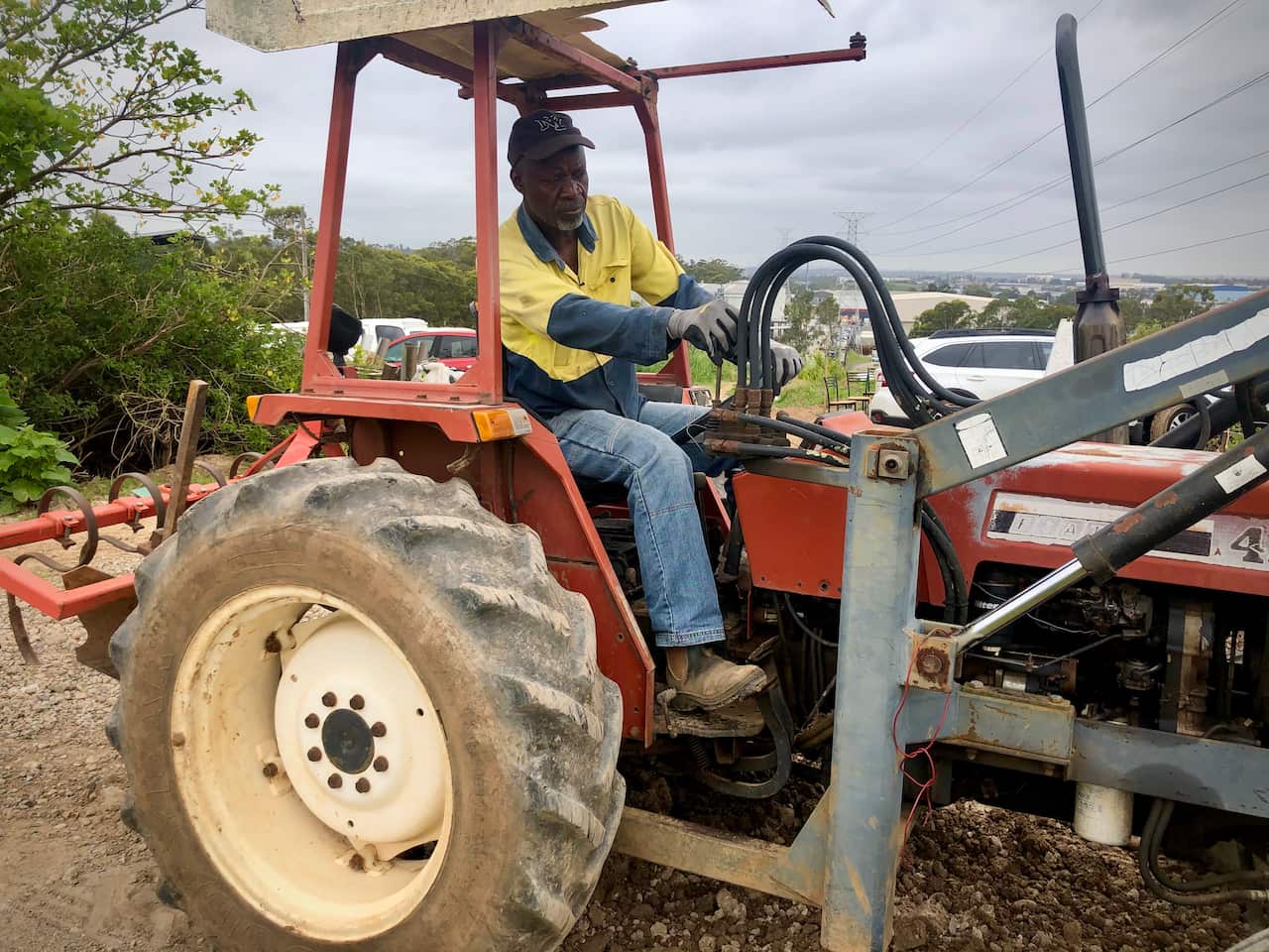 Bouk moves soil in an old red tractor.