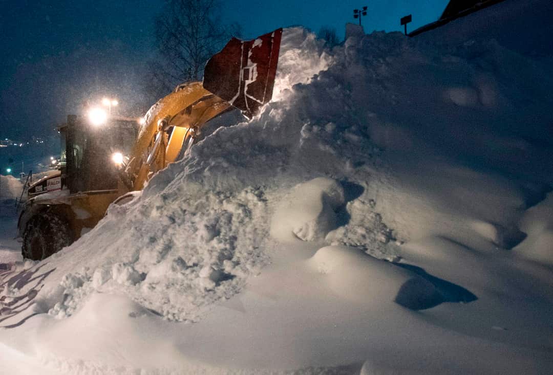 Workers use heavy machines to clear huge masses of snow from the streets of the village of Sankt Anton am Arlberg, Austria. 