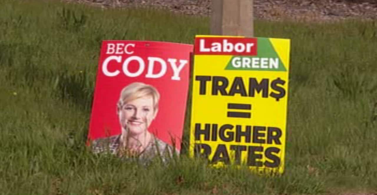 A Labor party corflute, sabotaged with a rival anti-tram corflute, in Canberra.  