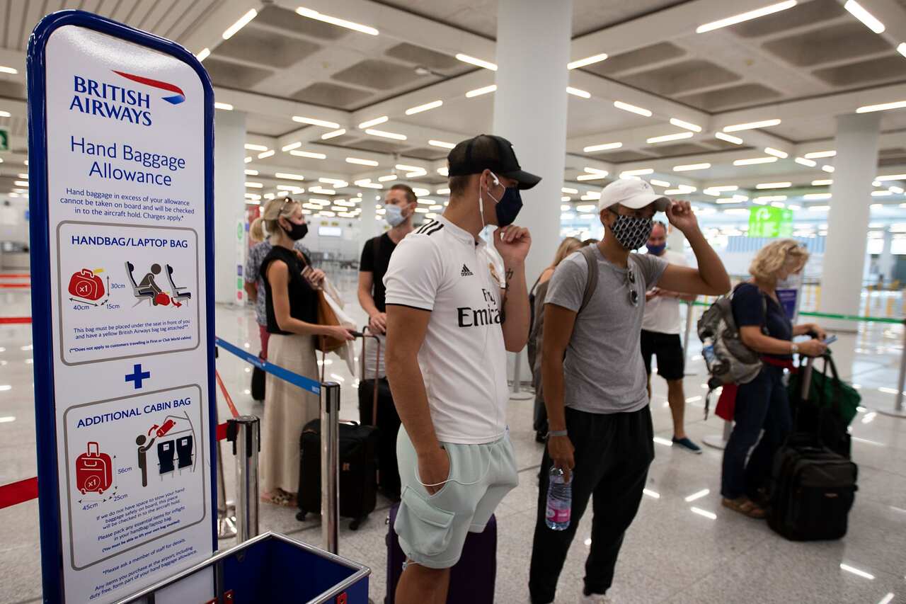 British tourists wait to check in for a flight to London at the airport in Palma de Mallorca on July 27, 2020. 