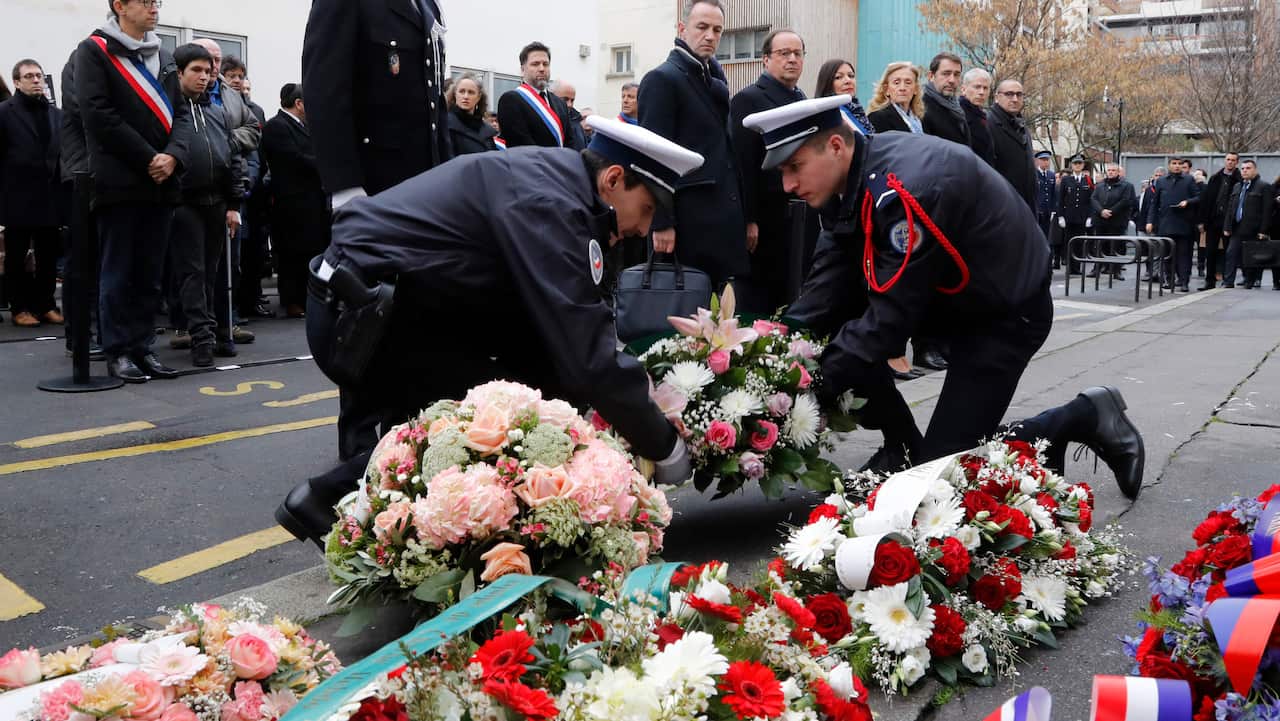 French former president Francois Hollande and Mayor of Paris Anne Hidalgo pay their respects outside Charlie Hebdo's former offices.