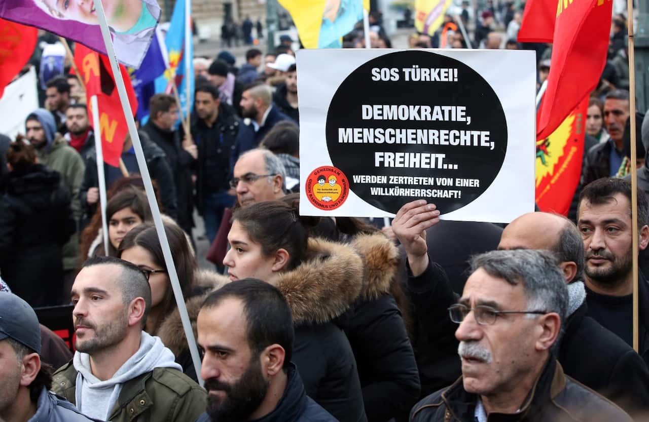 People with banners reading 'SOS Turkey! Democracy, human rights, freedom... are trodden by an arbitrary government' demonstrate against the arrests (AAP)