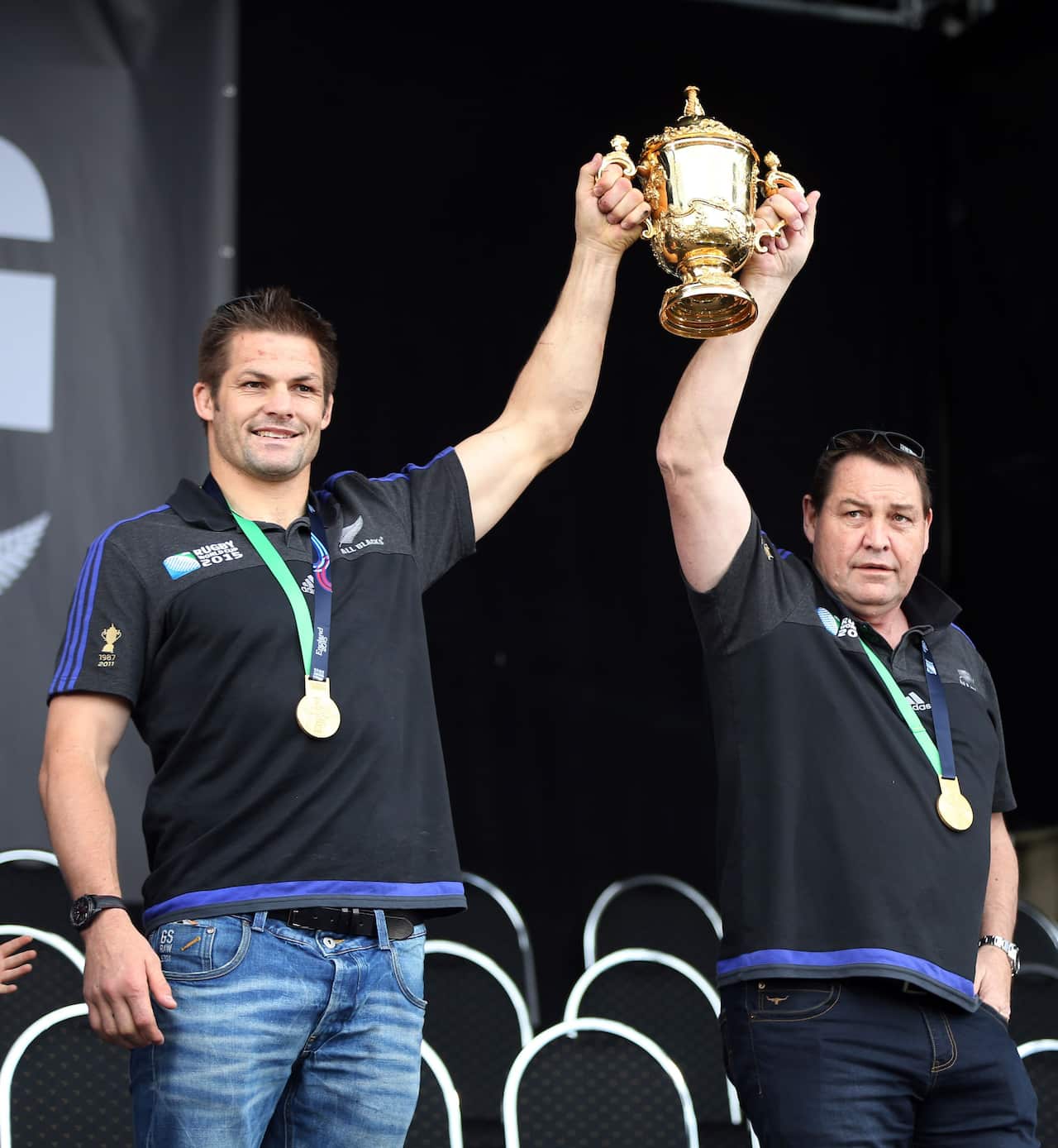 All Blacks captain Richie McCaw and coach Steve Hansen hold the Rugby World Cup trophy at a parade and official welcome for the New Zealand All Black rugby team in Auckland.