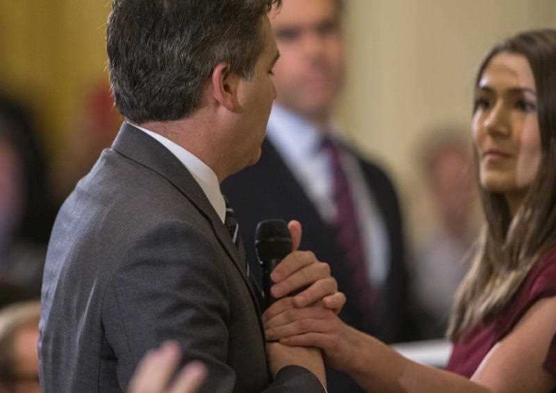CNN reporter Jim Acosta holds onto a microphone from an aide during a press conference with US President Donald Trump in the East Room of the White House.