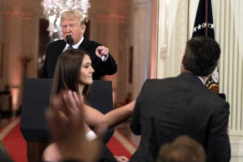 President Trump shouts at the CNN reporter as an aide attempts to wrestle the microphone back.