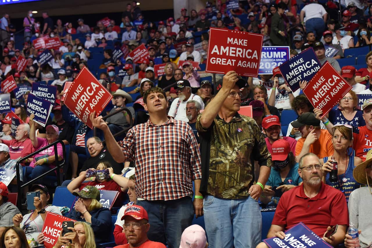 Supporters of US President Donald Trump hold placards during a rally inside the Bank of Oklahoma Center in Tulsa.
