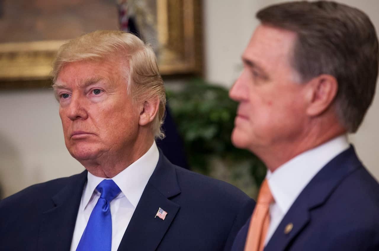 US President Donald J. Trump (L) and Senator David Perdue (R), a Republican from Georgia, listen as Senator Tom Cotton