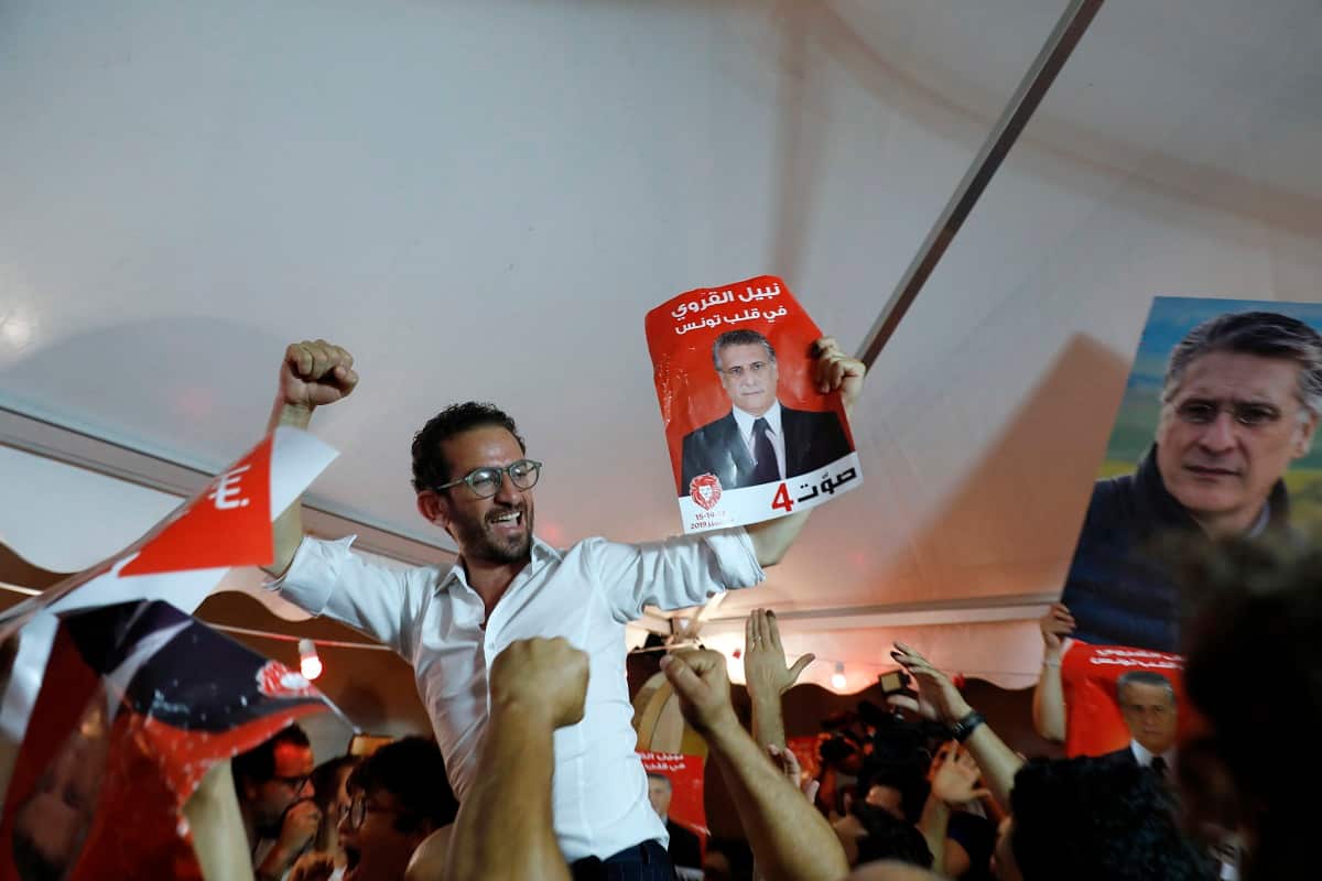 Supporters of Tunisia's jailed presidential candidate Nabil Karoui celebrate in front of his headquarters as results come in, in Tunis, Tunisia.