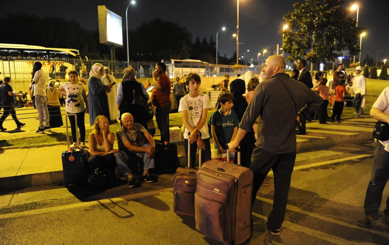 Passengers wait outside the Turkey's largest airport, Istanbul Ataturk after the suicide bomb attacks, June 28, 2016, Turkey. (Getty)