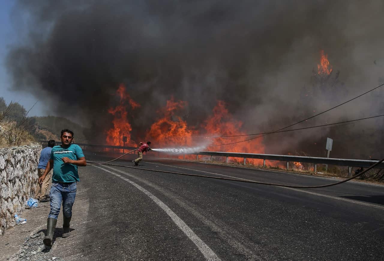Firefighters try put out the wildfires at the rural of Marmaris district of Mugla, Turkey.