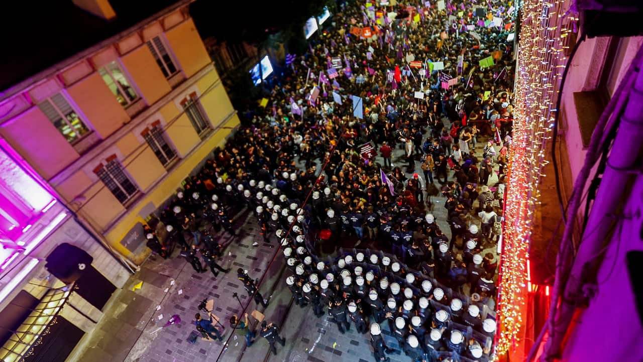 Thousands of women shout slogans as Turkish police block the roads during a rally marking the International Women's Day.