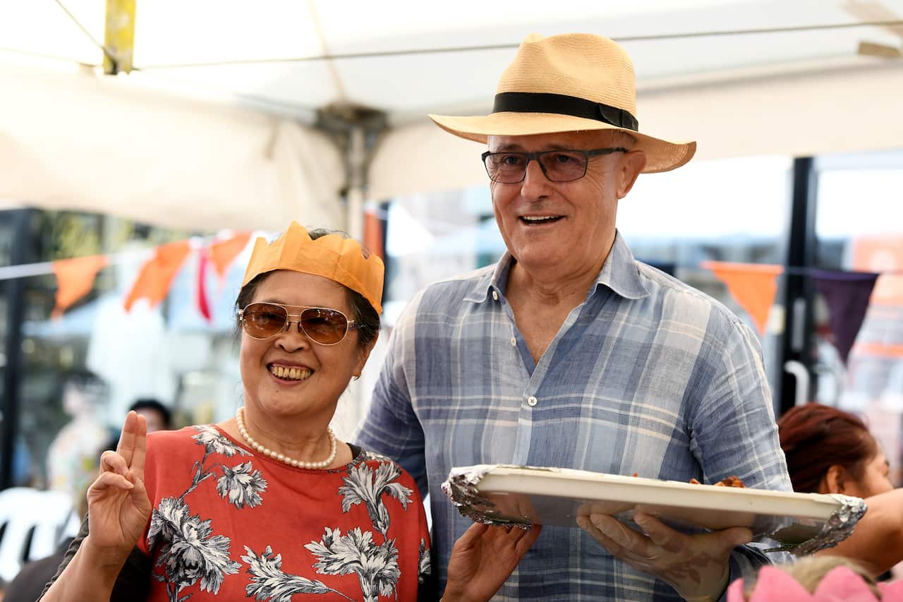 Mr Turnbull poses for a photo with a local after helping out serving food.
