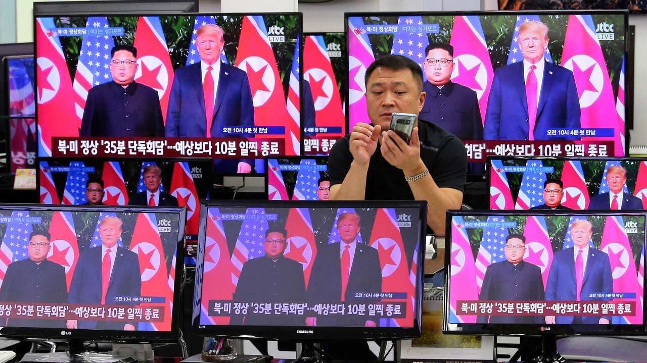 TV screens show US President Donald Trump, right, meeting with North Korean leader Kim Jong Un in Singapore.