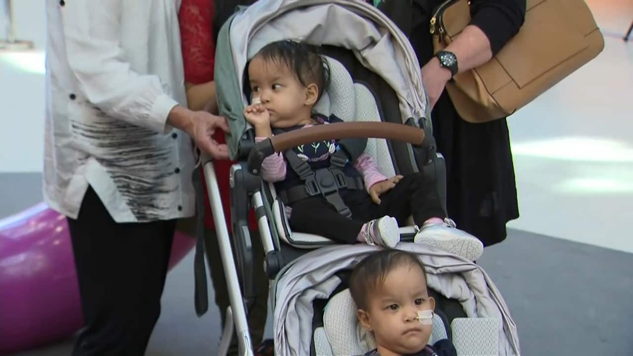 Bhutanese twins Nima and Dawa are wheeled out of hospital.