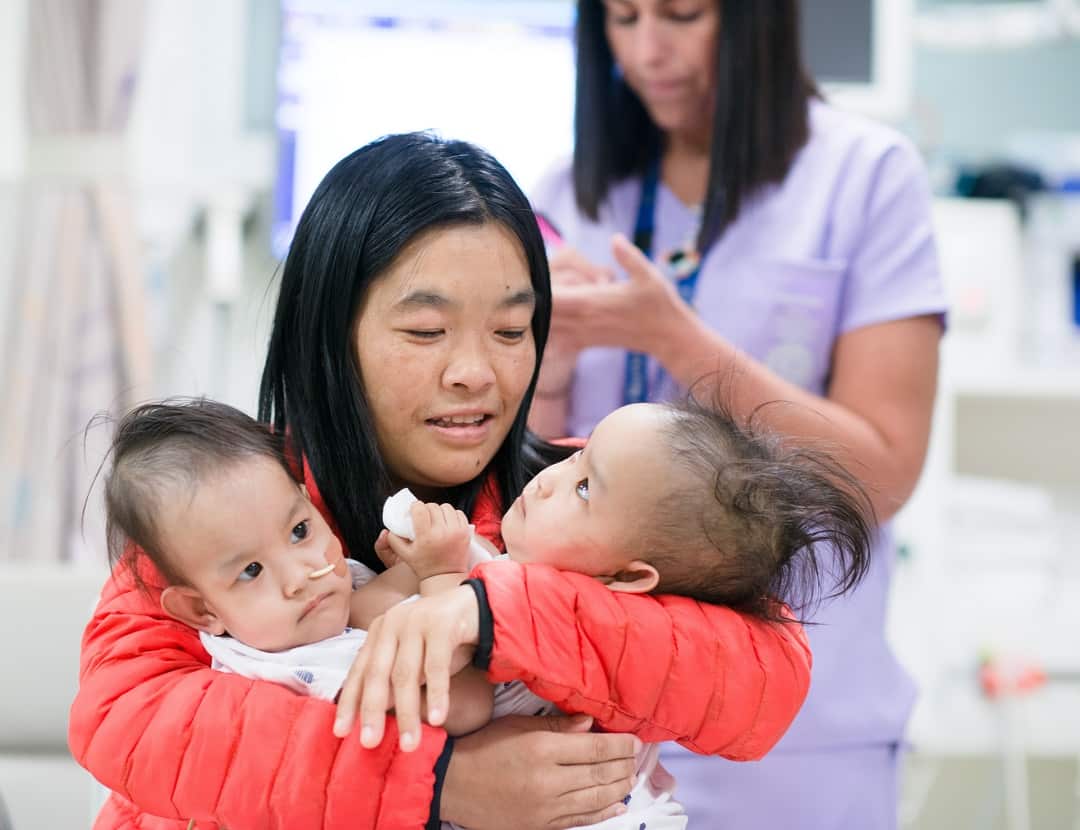 The conjoined twins with their mother before going into surgery. 
