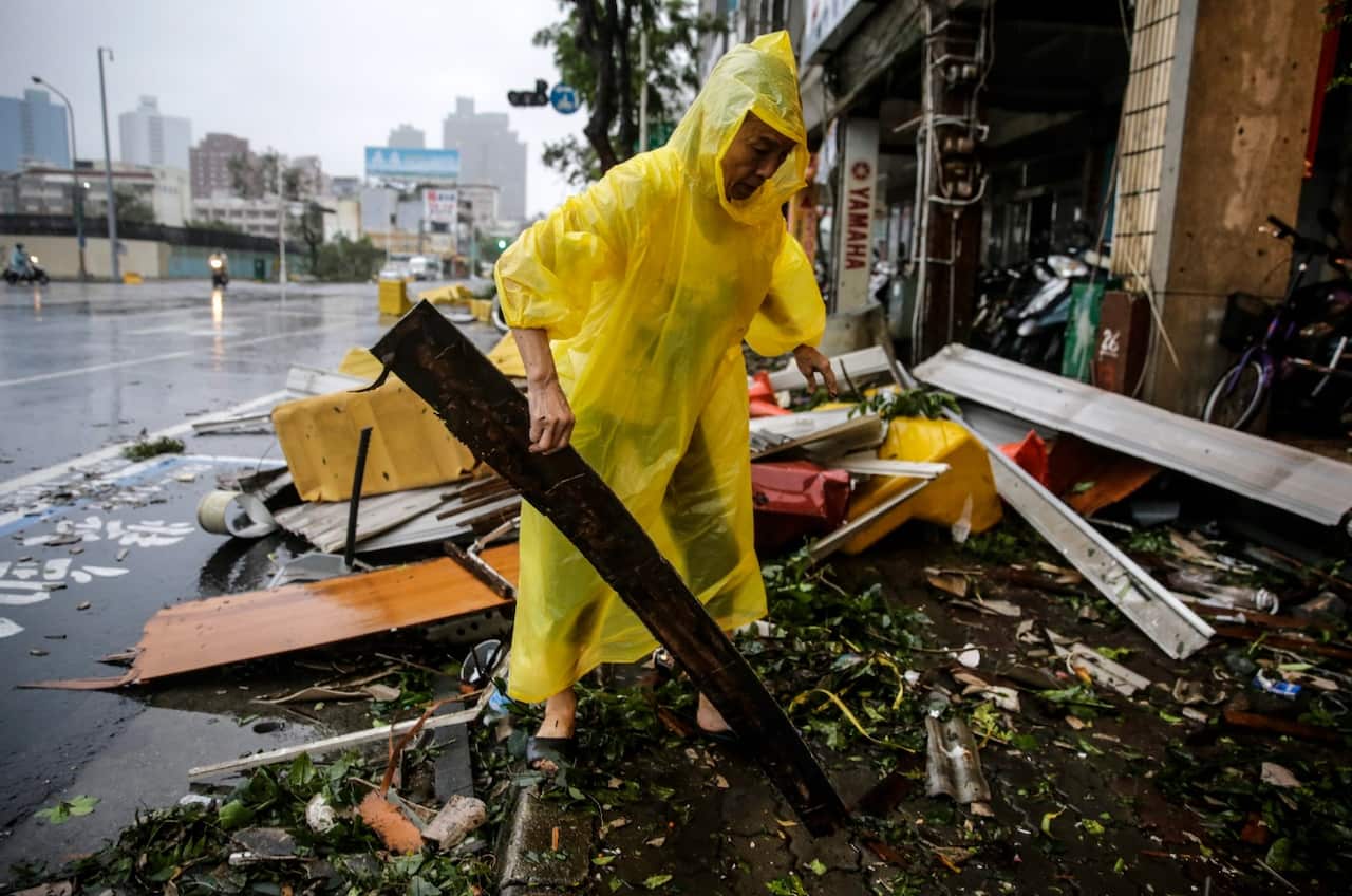 A man salvages usable materials from debris after strong winds and rain from Super Typhoon Meranti in Kaohsiung, southern Taiwan (AAP) 