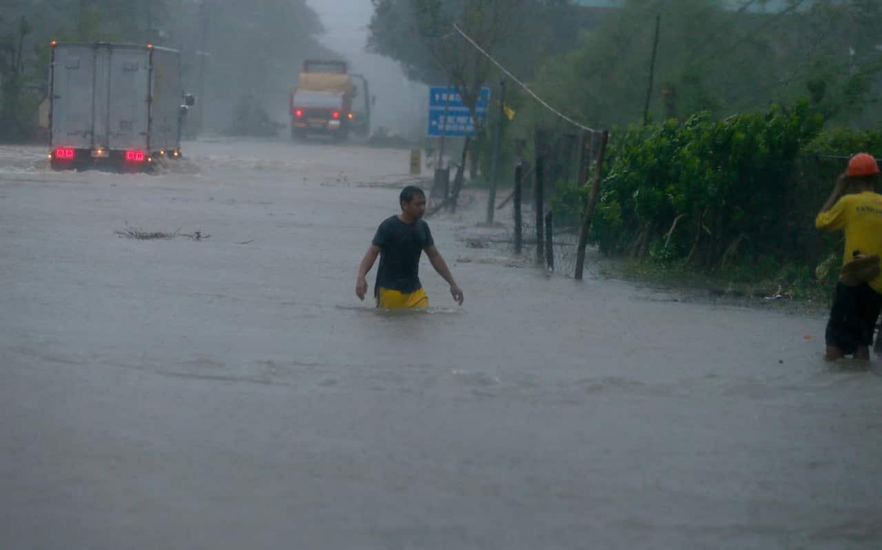 A man wades through a flooded highway at the height of Super Typhoon Haima that lashed the northern Philippines on Oct 20