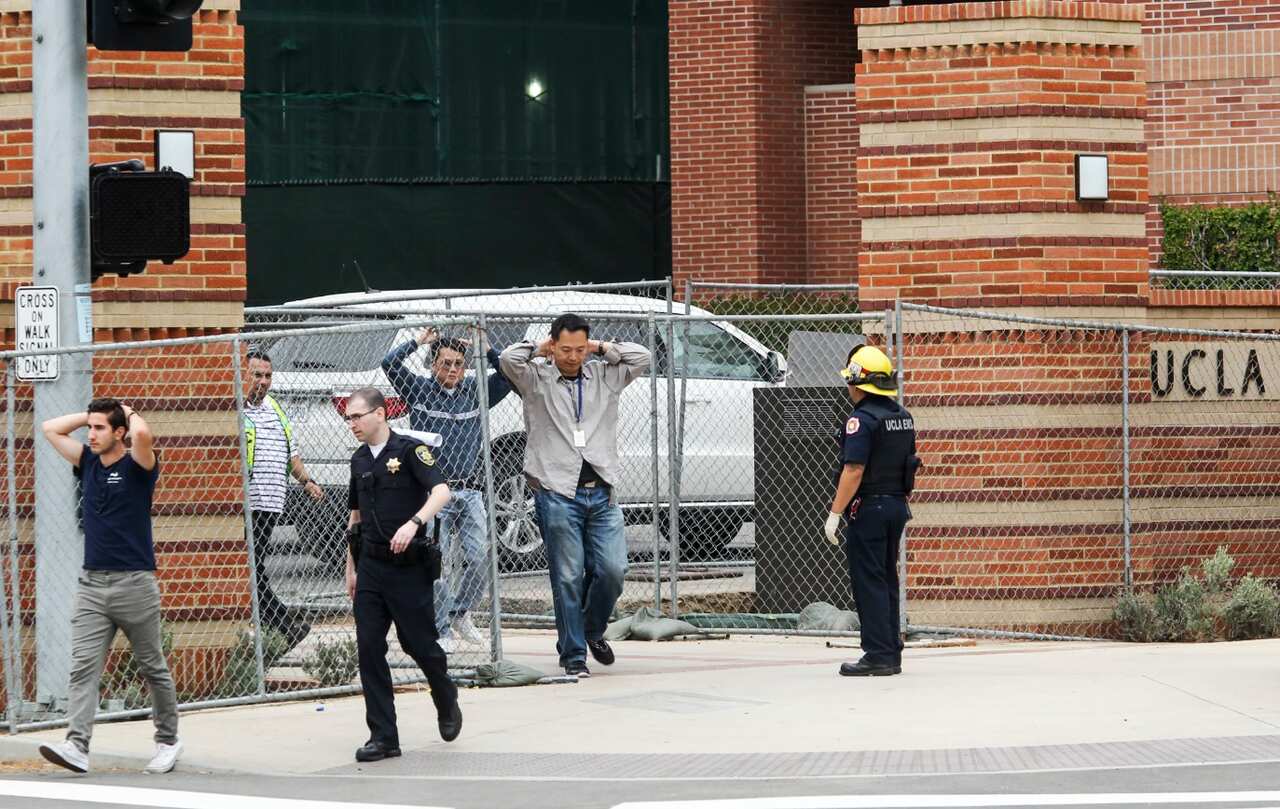 People are escorted by emergency personnel away from the scene of a fatal shooting at the University of California, Los Angeles (AAP)