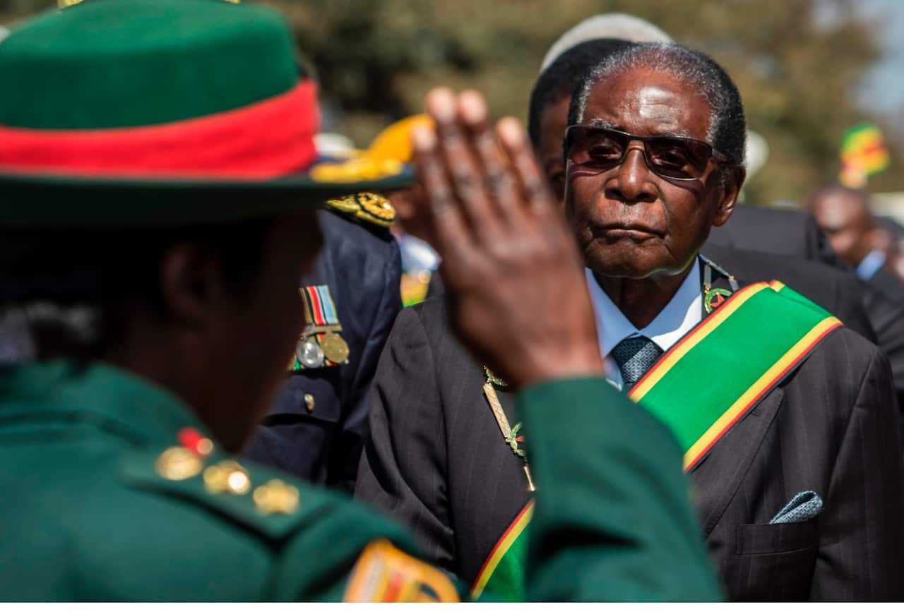 File image: Former Zimbabwe President Robert Mugabe (R) inspects a guard of honour during official Heroes Day commemorations in August 2017 