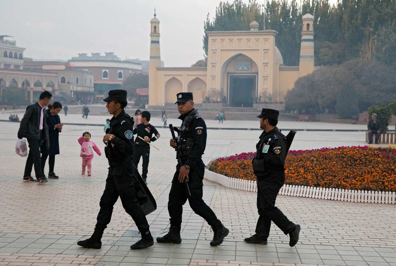 In this Nov. 4, 2017, file photo, Uighur security personnel patrol near the Id Kah Mosque in Kashgar in western China's Xinjiang region.
