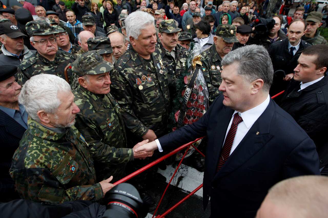 Ukrainian President Petro Poroshenko (R) chats with liquidators near to the monument 'To Heroes of Chernobyl' (Getty)