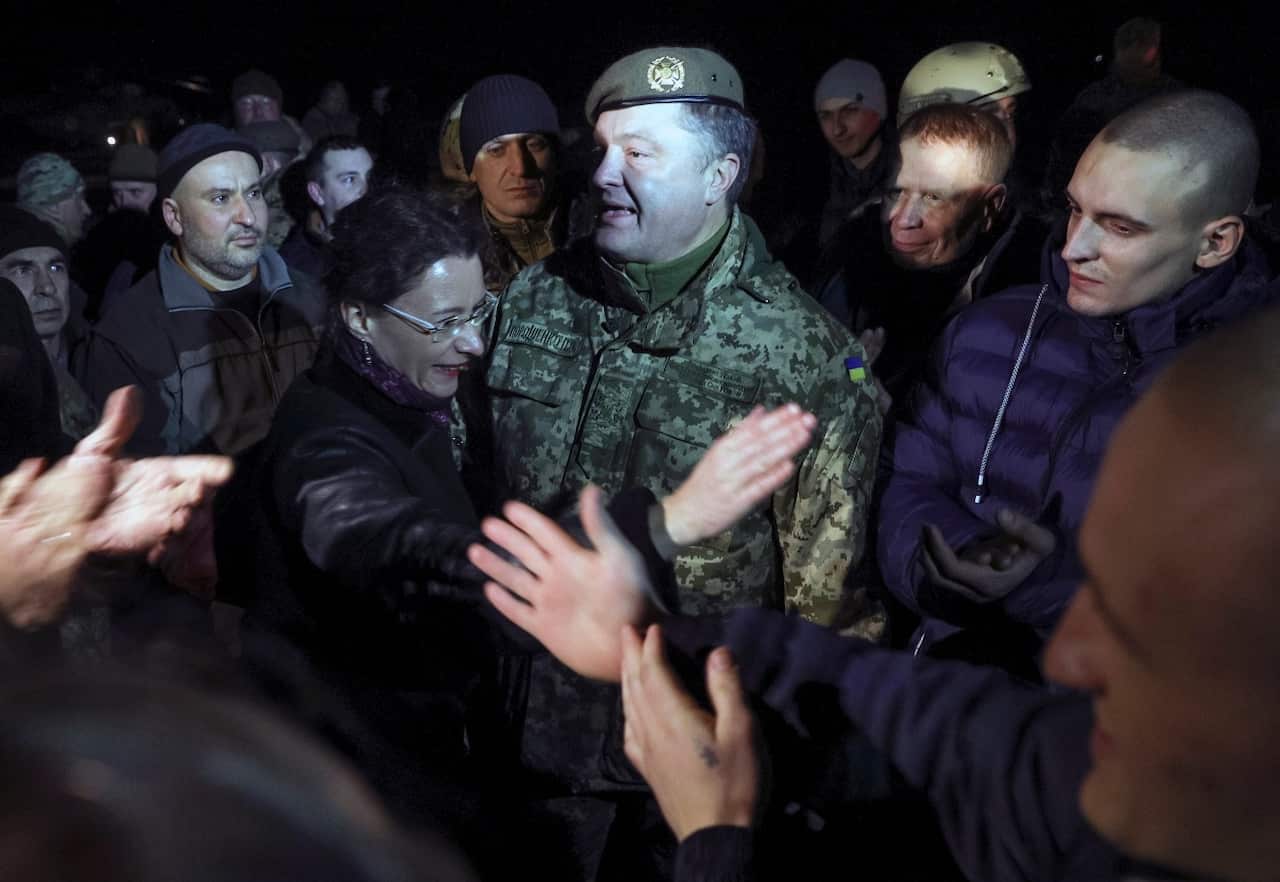 Ukrainian President Petro Poroshenko, center, speaks to prisoners who were released by separatists in the town of Kramatorsk, eastern Ukraine in December 2017.