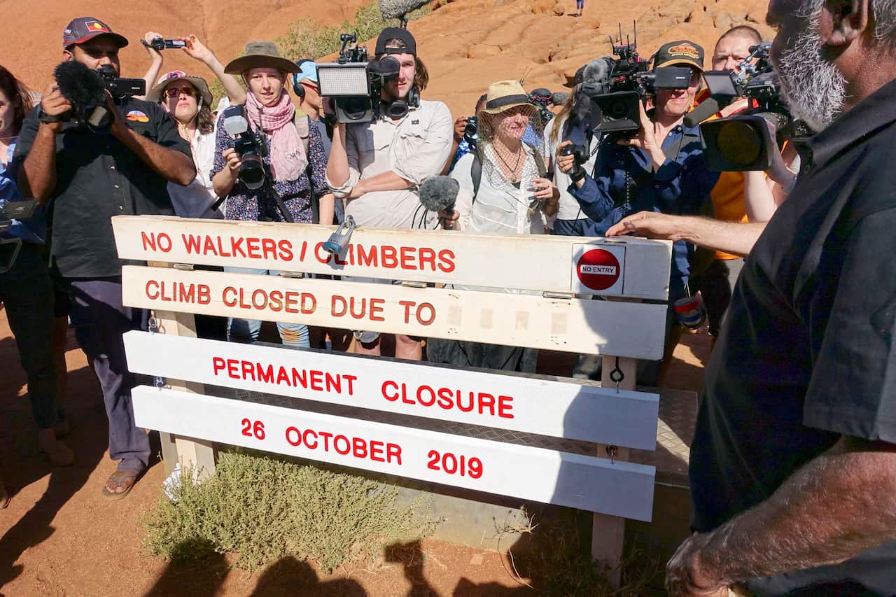 A sign announcing the controversial Uluru climb's "permanent closure" is erected at the base of the iconic Australian monolith previously known as Ayers Rock, on Oct. 25, 2019. (Kyodo via AP Images) ==Kyodo