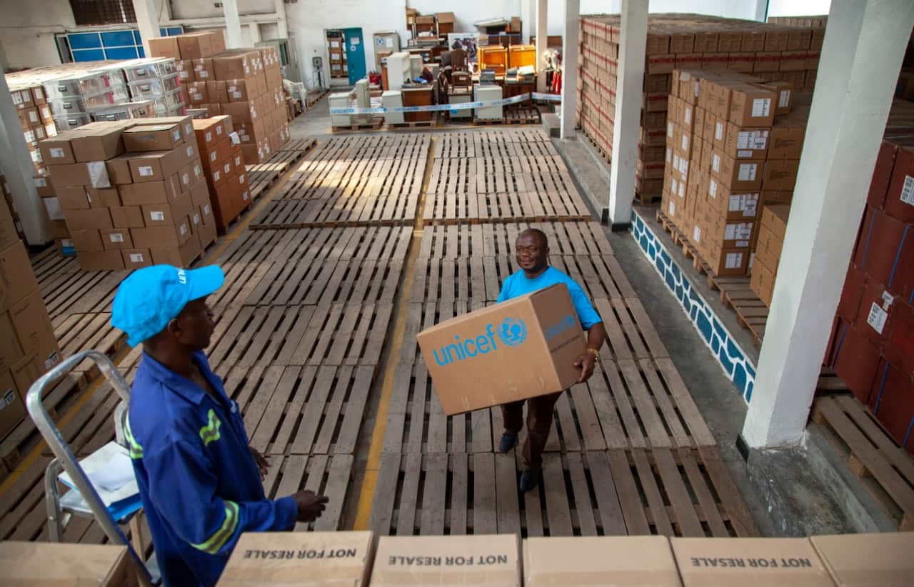 A handout photo made available by UNICEF shows Patrick Lonji, UNICEF Supply and Logistics Officer, carrying supplies through a UNICEF warehouse in North Kivu