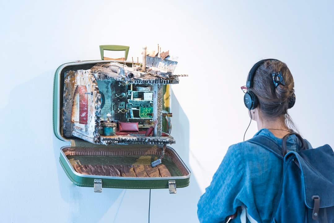 A viewer listening to an audio piece which comes with the art.