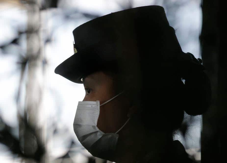 A security guard wears a mask as she keeps watch at arriving passengers at Manila’s international airport in the Philippines.