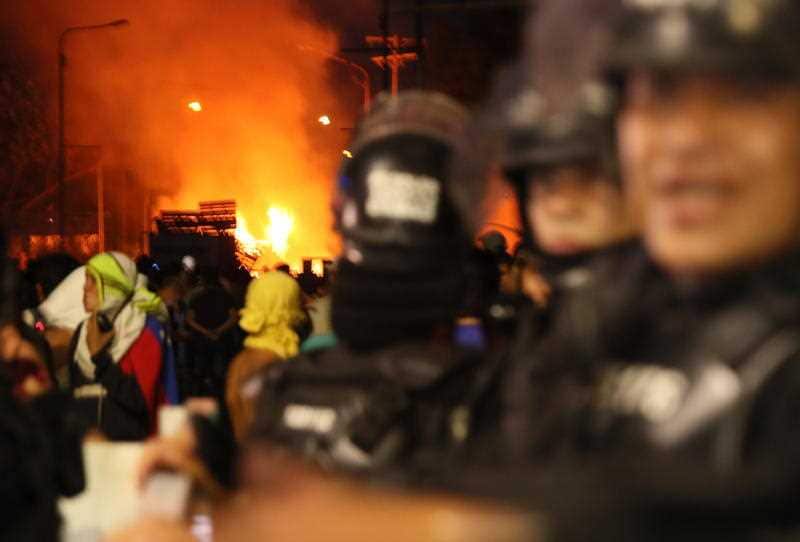 Members of the Colombian police try to vacate the bridge for security, while demonstrators clash with members of the Bolivarian National Police.