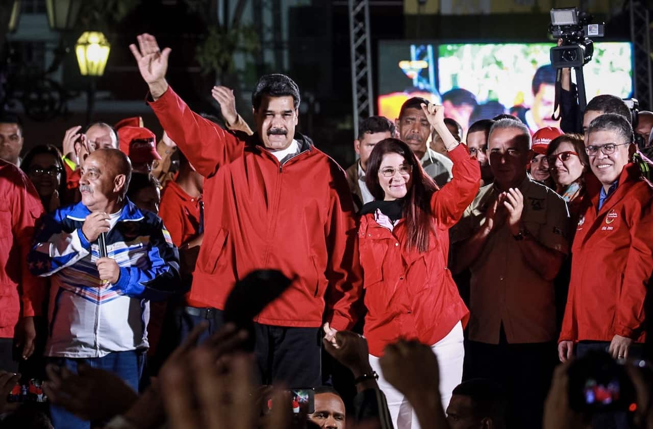 Venezuelan President Nicolas Maduro (C-L), together with his wife and deputy of the National Assembly Cilia Flores (C-R), celebrate election results