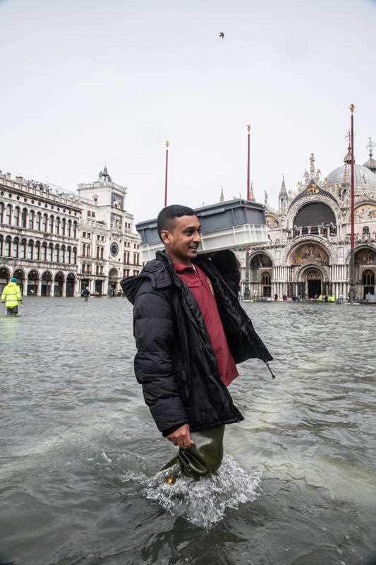 A local walks through floodwaters in Venice.