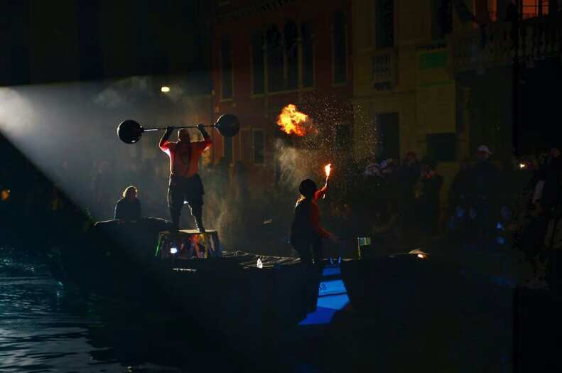 Circus performers hold up barbells and breathe fire as part of Venice Carnivale celebrations
