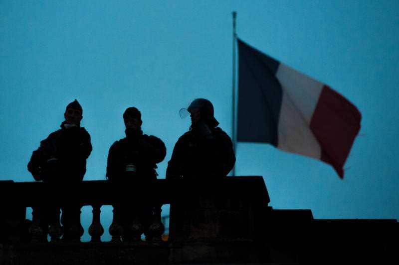 Riot police watch Yellow Vest protesters during a demonstration in Bordeaux, France.