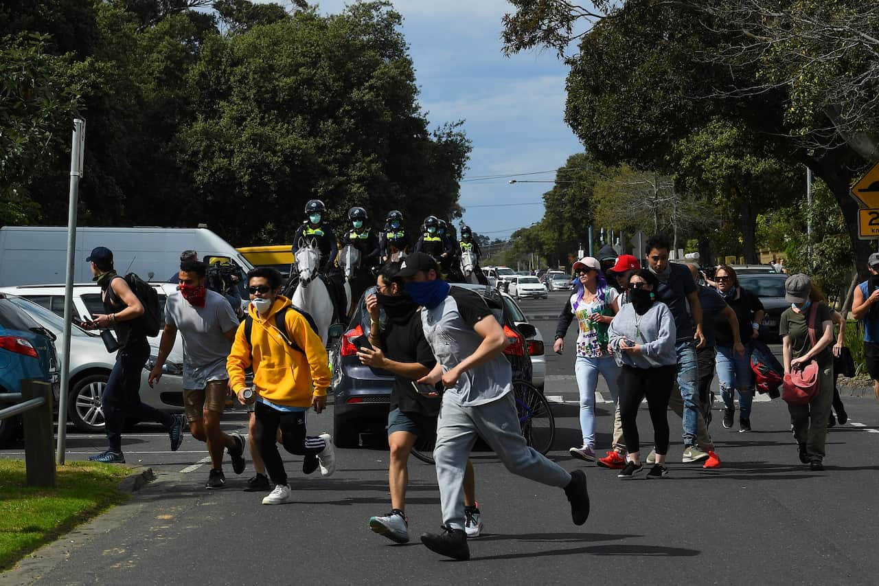 Some protesters marched along Elwood Beach in a loose formation before they were dispersed by police.
