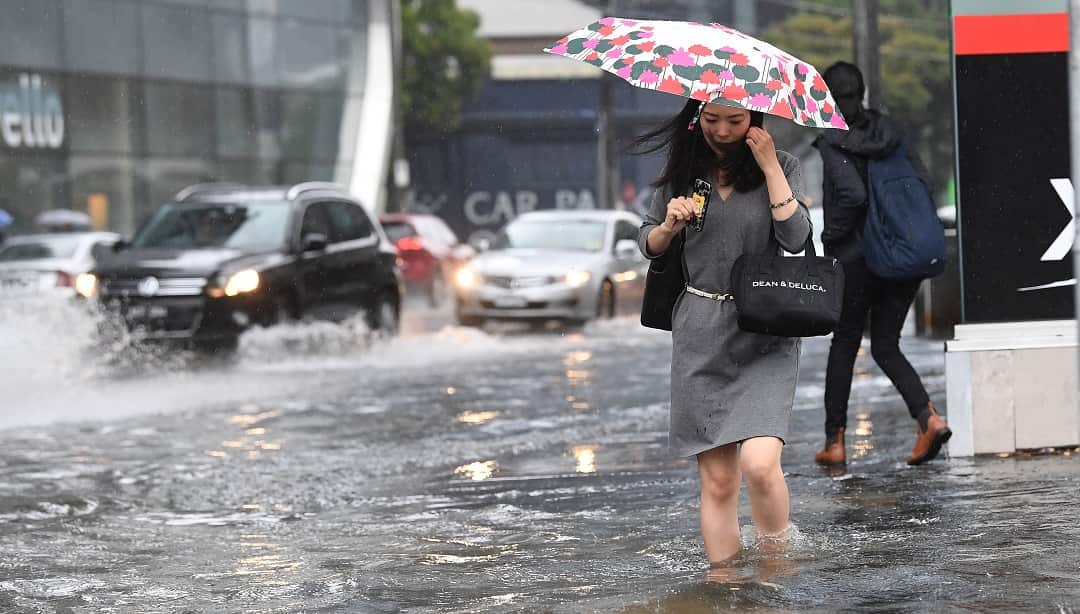 Pedestrians walk through flood waters.