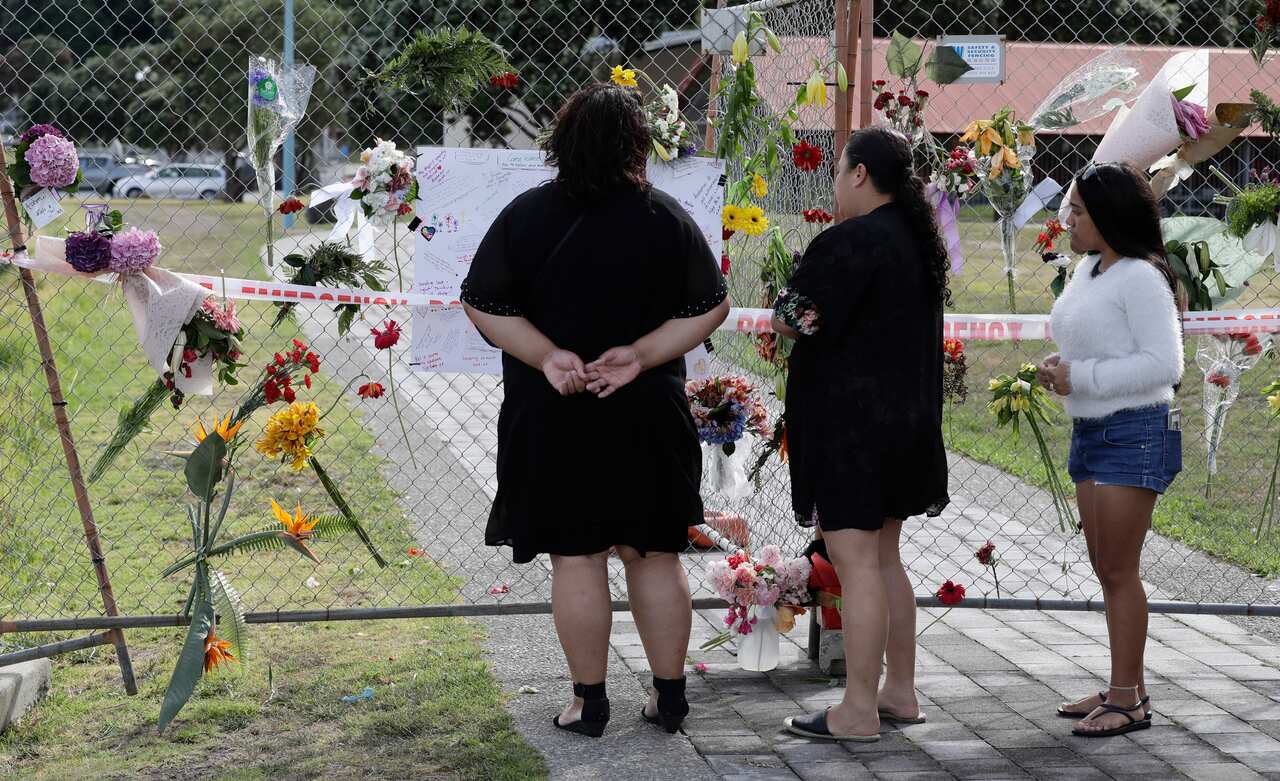 Relatives of volcano victim Hayden Marshall-Inman visit a flower tribute on the waterfront in Whakatane.