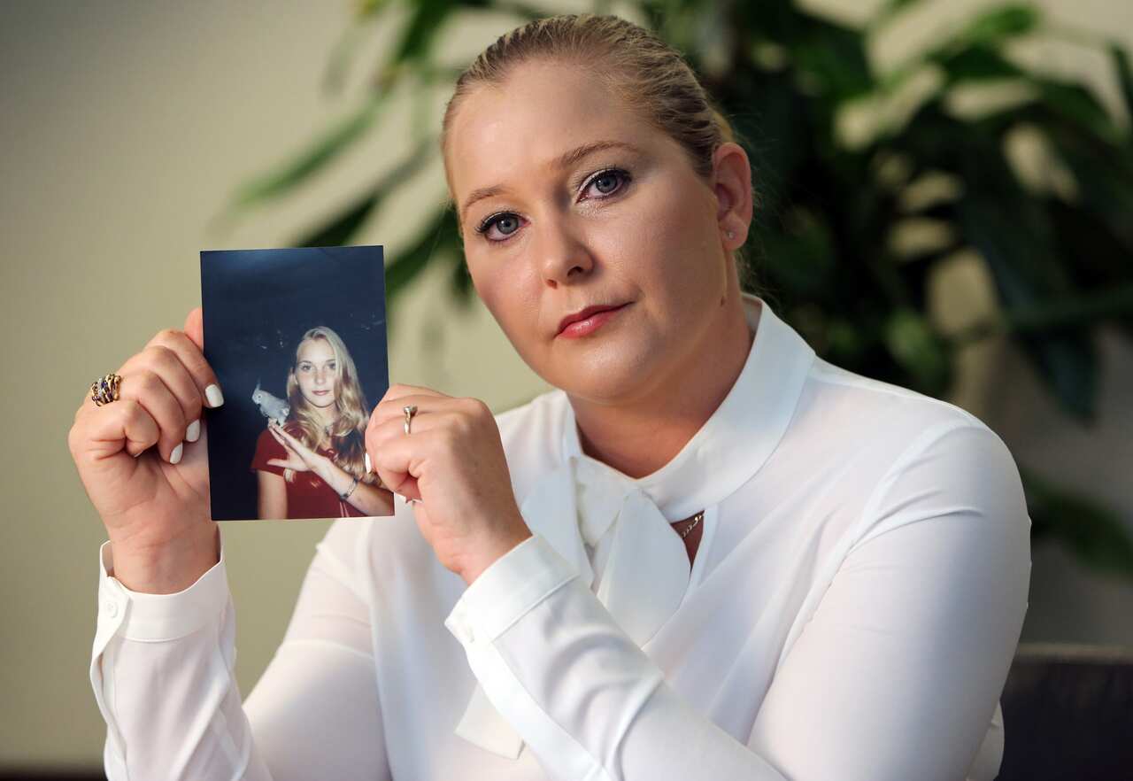Virginia Giuffre, holding a photo of herself at age 16, when she says Jeffrey Epstein began sexually abusing her. 