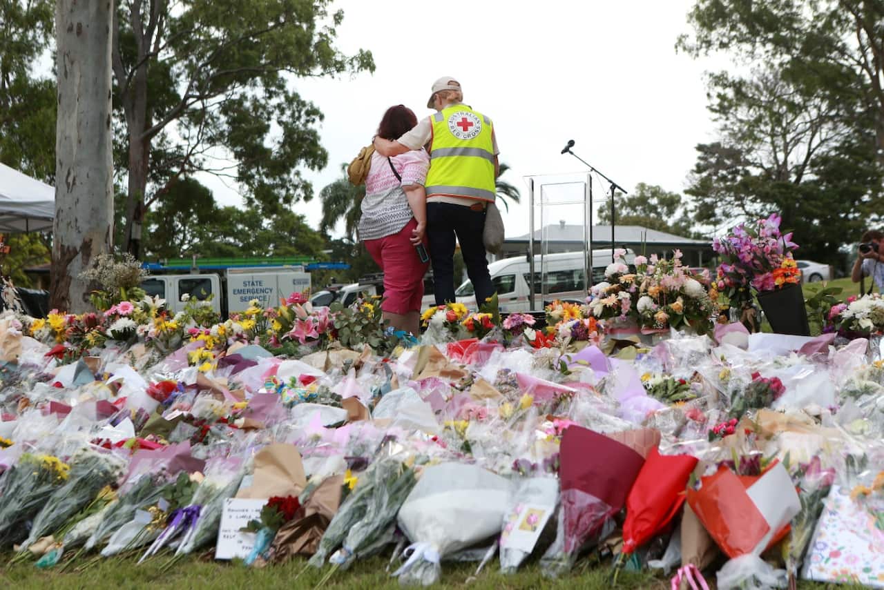 The Red Cross comforts a woman at the vigil for Hannah Clarke and her three children