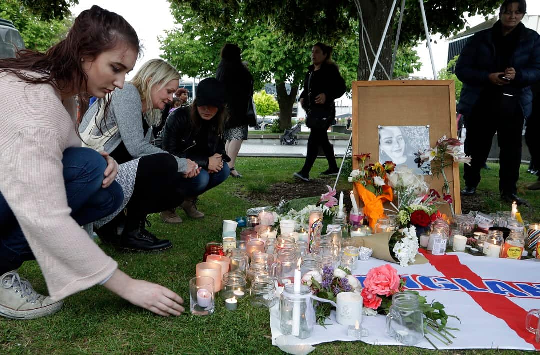People lay flowers and light candles during a candlelight vigil for British tourist Grace Millane.