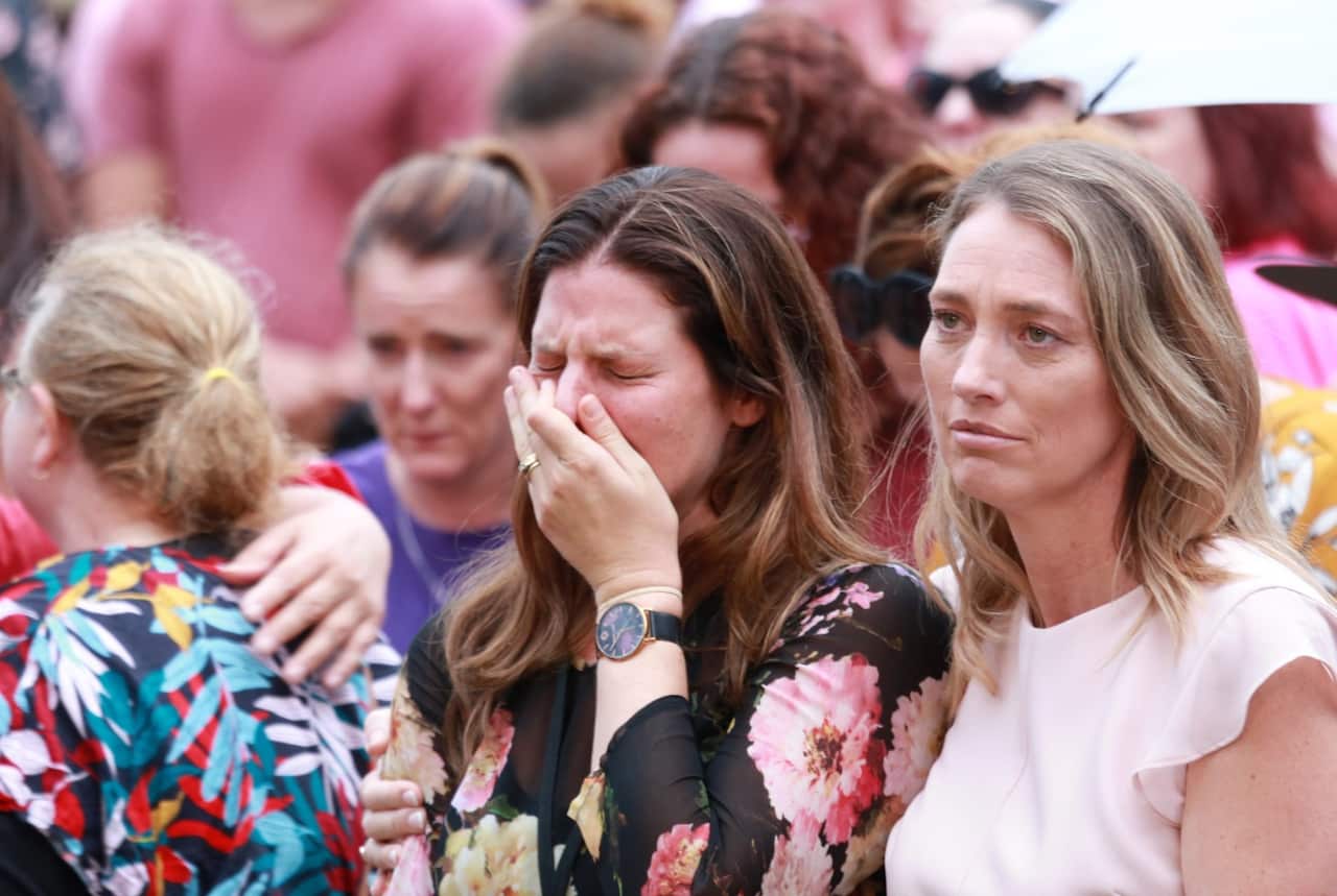 A woman in the crowd sheds a tear at the vigil for Hannah Clarke and her three children