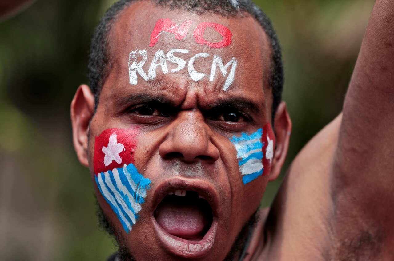 A Papuan activist with his face painted with the colors of the separatist Morning Star flag shouts slogans during a recent rally. 