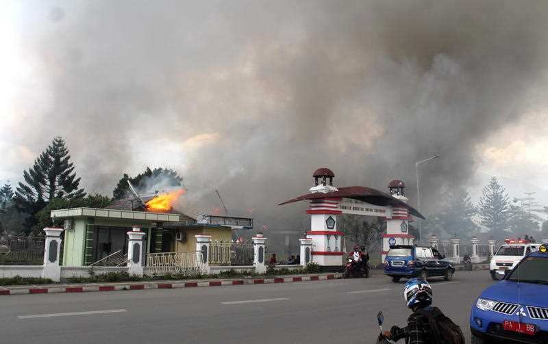 Smoke rise from a burning building during a violent rally in Wamena, Papua Province, Indonesia.