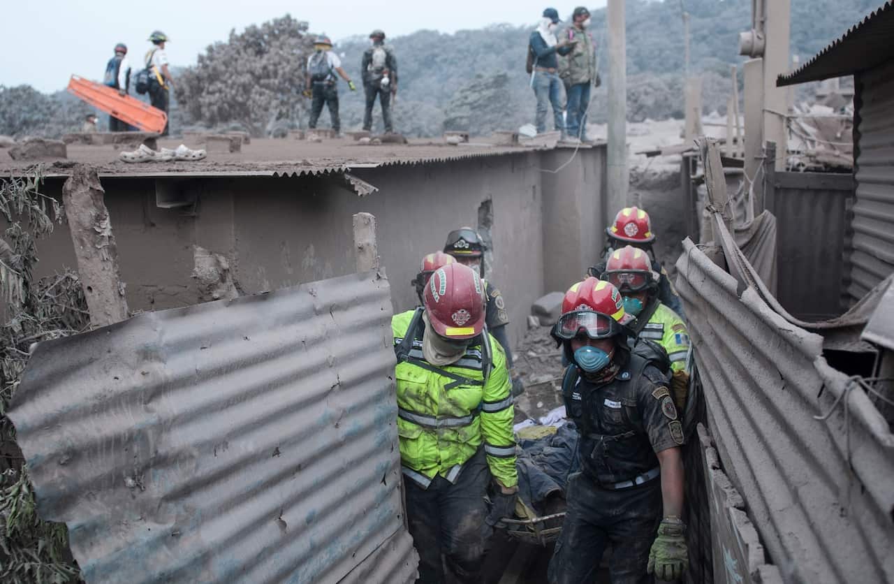 Firefighters remove a body recovered near the Volcan de Fuego, or "Volcano of Fire," in Escuintla