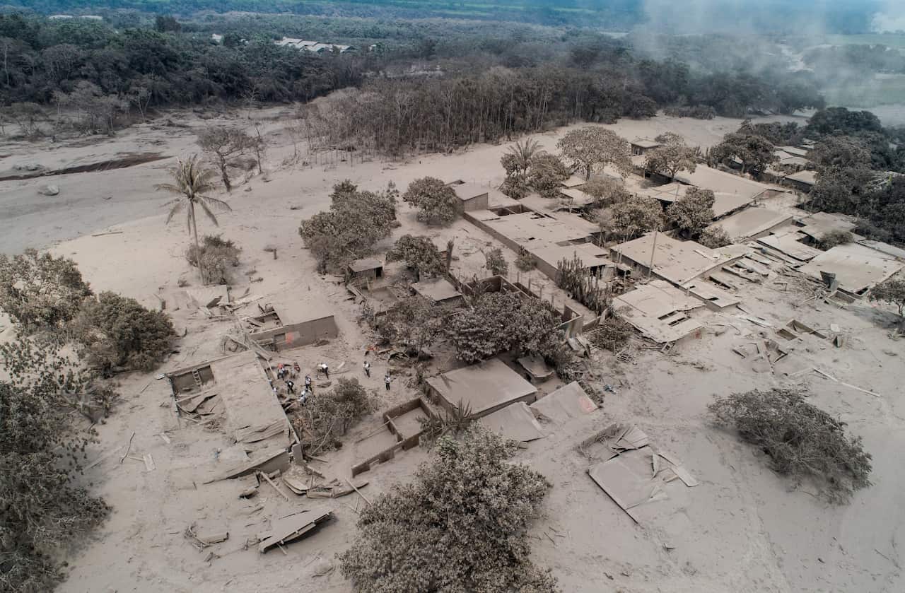Rescue workers search in El Rodeo, one of the hamlets in the disaster area