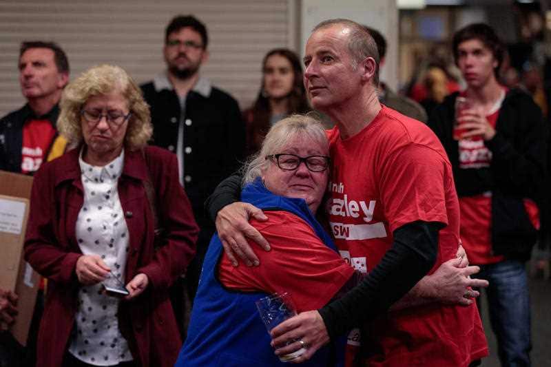 Devastated Labor volunteers watch on as the election result plays out on television. 