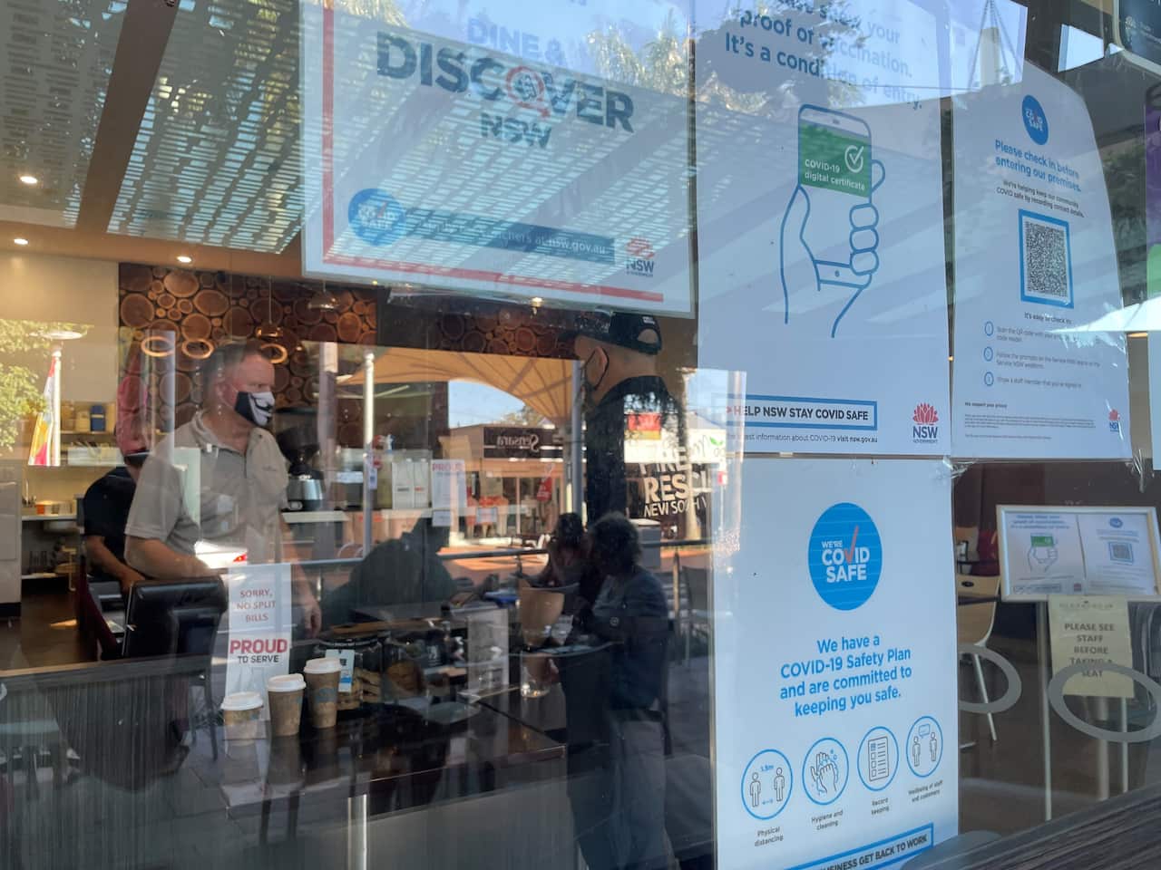 A cafe owner serves a customer.